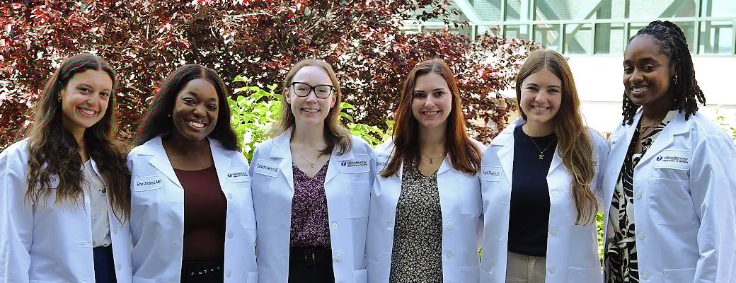 Six people wearing white coats