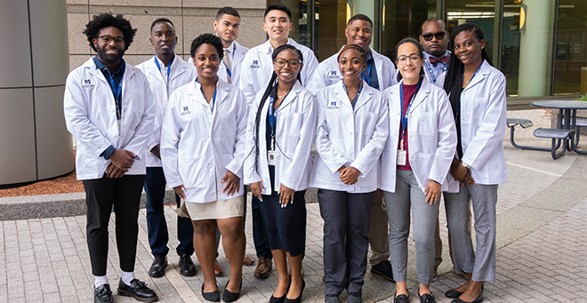 Students in white coats standing together outside