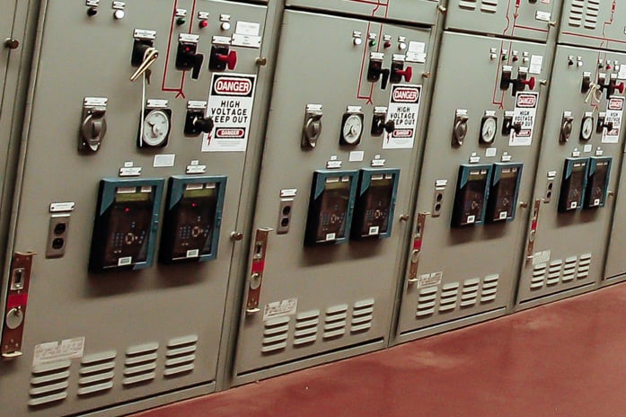 The image shows a row of switchboards located inside the power plant
