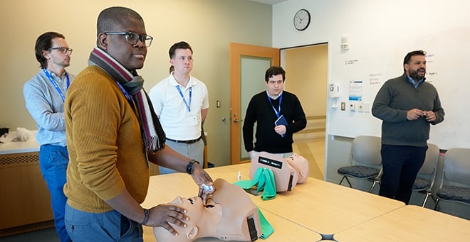 Participants standing around a table with a manikin