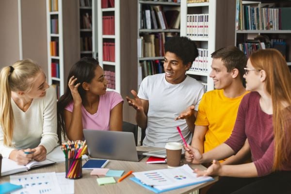 group of teens in a library chatting