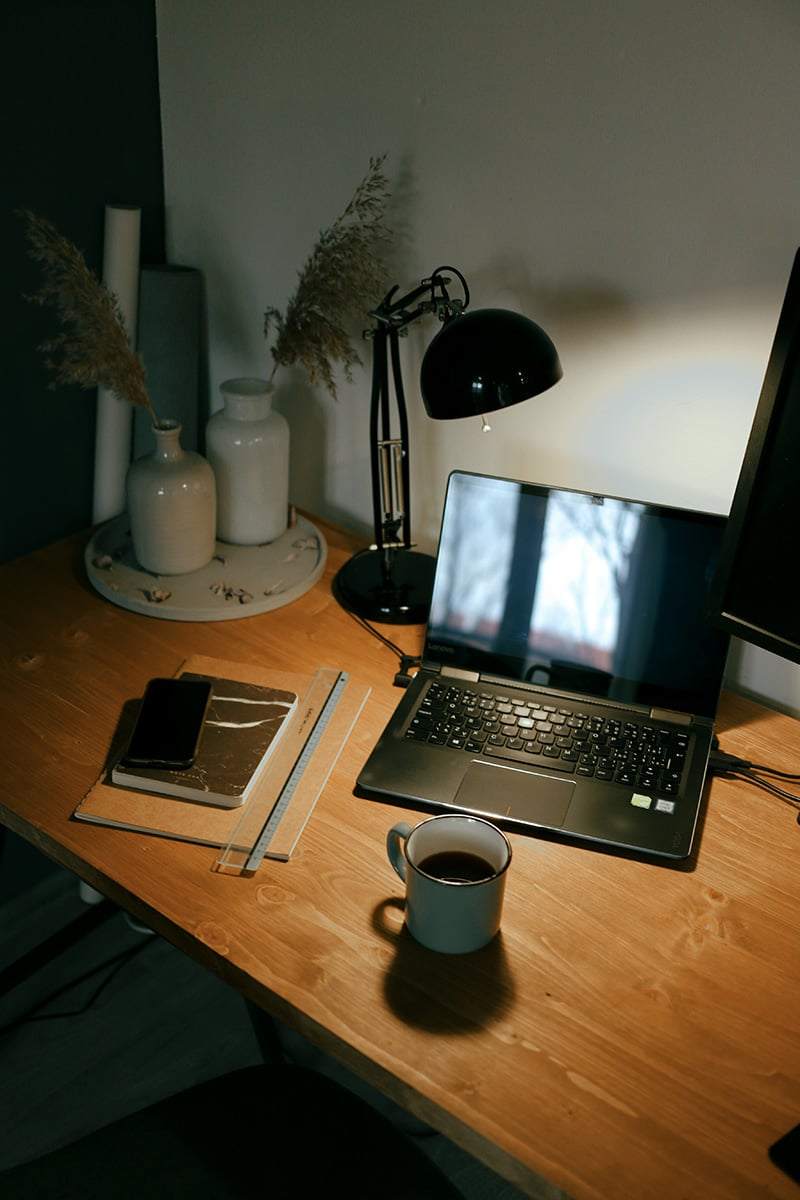 black lamp on a desk with a laptop
