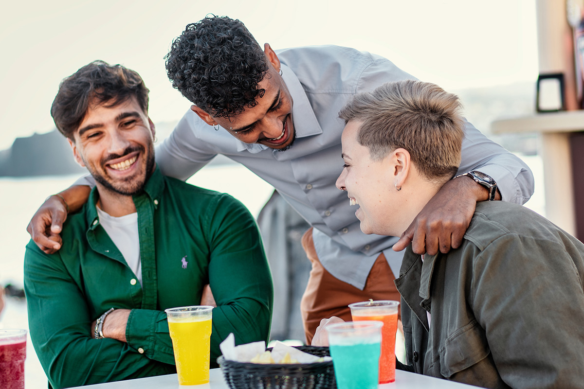 three men outside at a cafe laughing